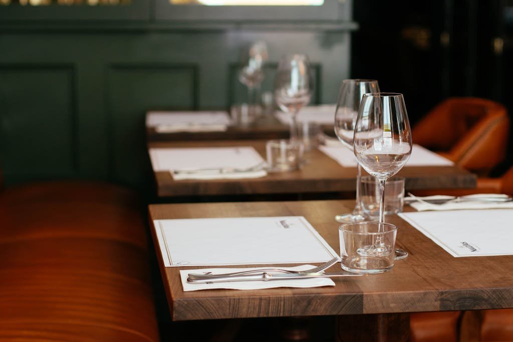 Chic restaurant table setting complete with cutlery and crystal wine glasses for an upscale dining experience.